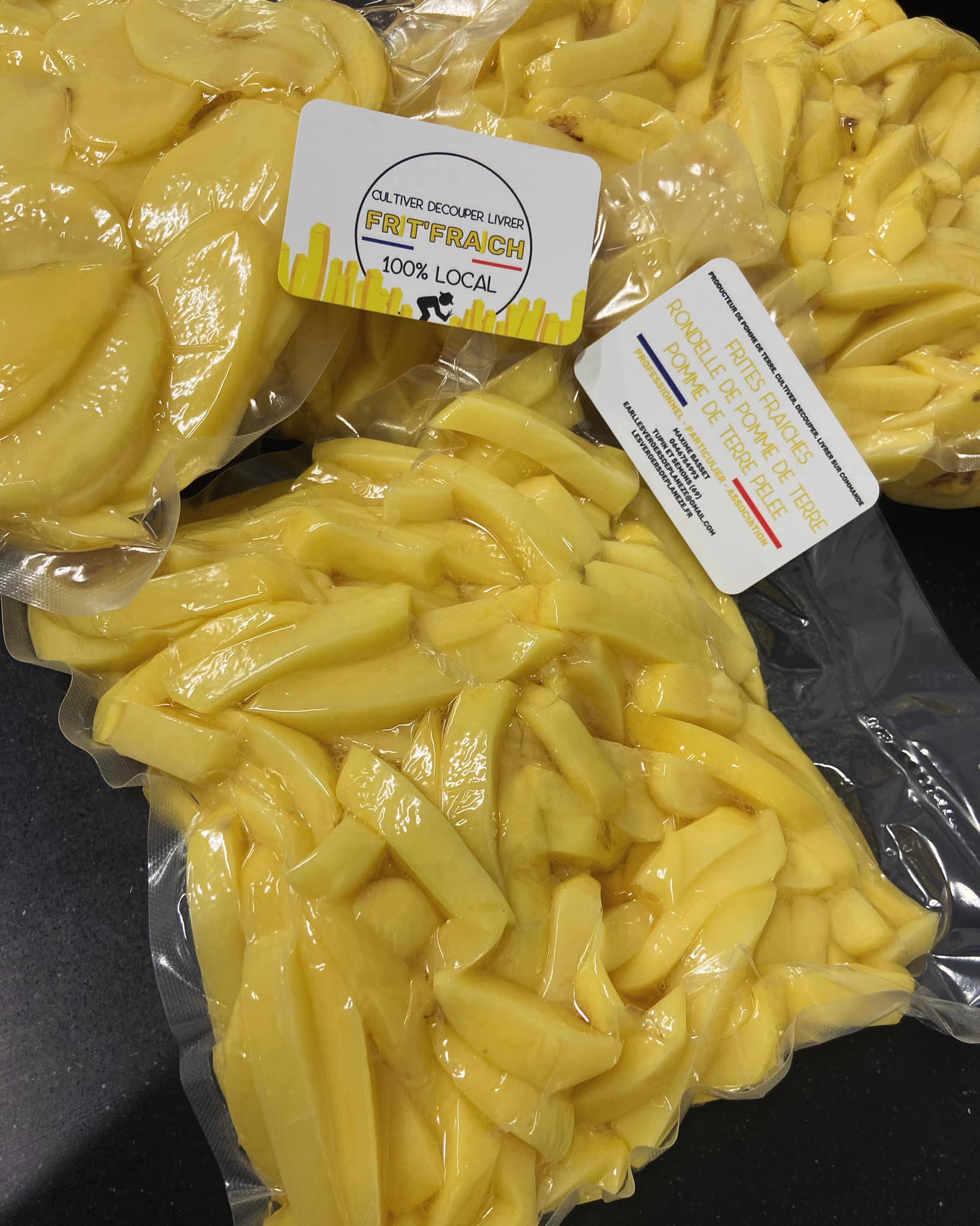 Sacs sous vide de frites fraîches prêtes à cuire, avec étiquettes indiquant « FR'T'FRAICH 100% LOCAL » et « POMME DE TERRE PEELEE ».